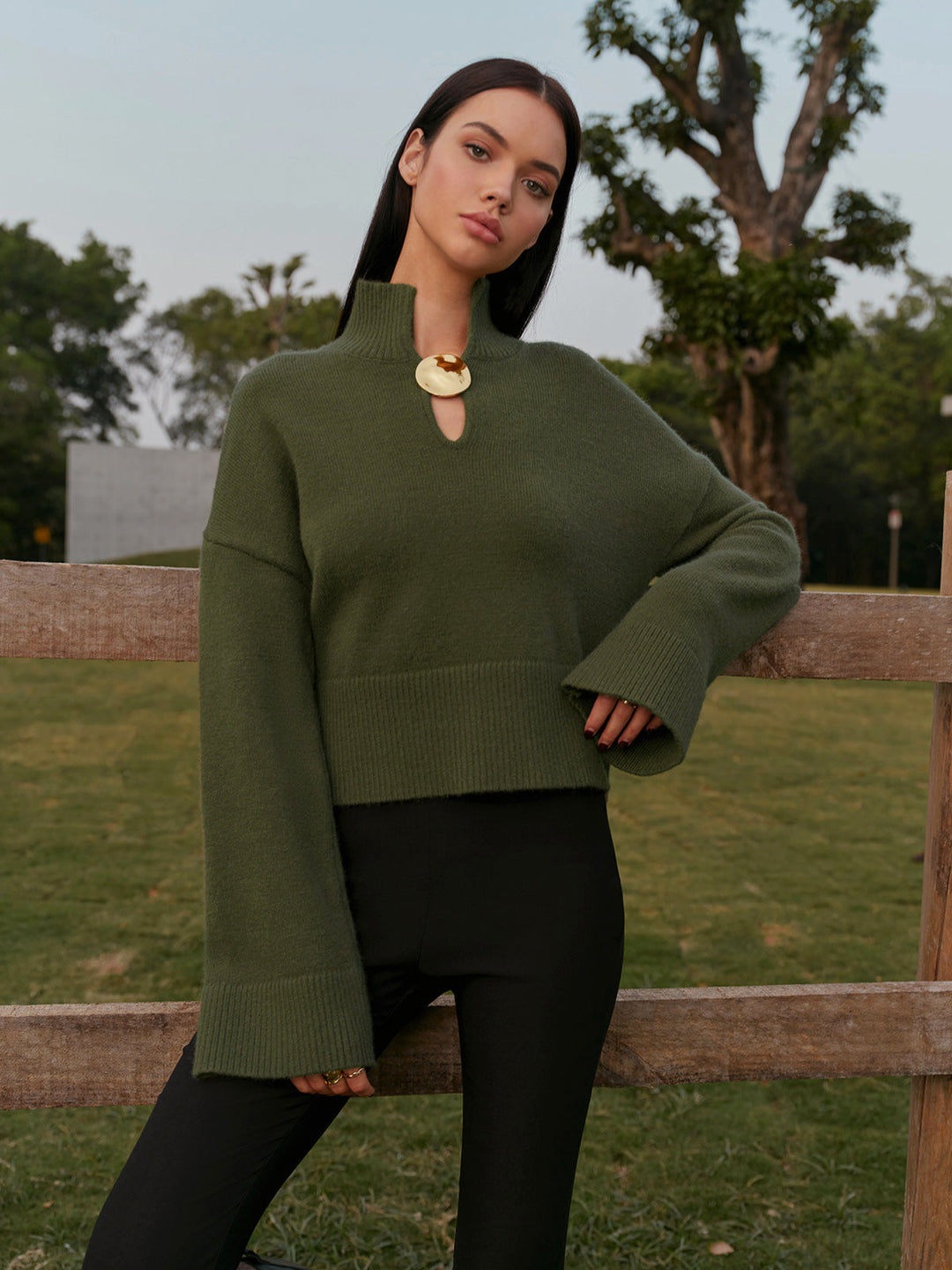 Şık metal detaylarla tasarlanmış yüksek yaka kazak