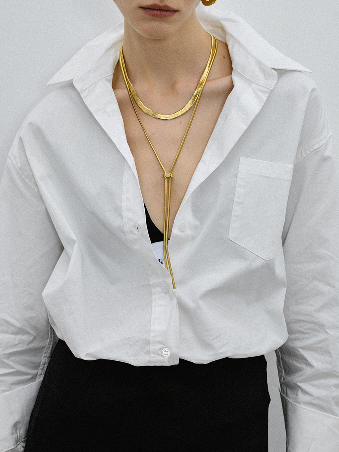 Y Harfi Püsküllü Kolye, titanyum çelikten yapılmış, zarif bir tasarım.